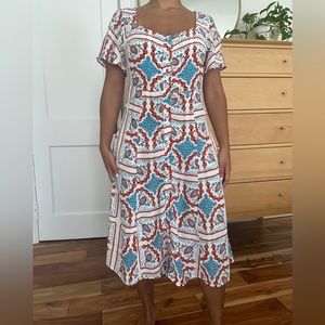 White floral graphic sleeved dress with buttons, cinched waist, and pockets